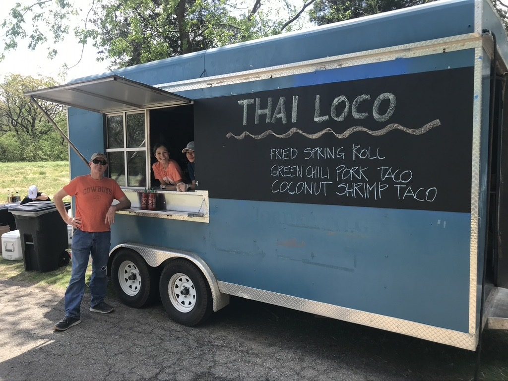 The blue Thai Loco food truck with a chalkboard menu